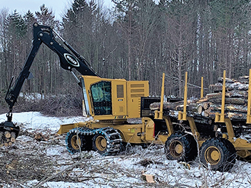 forestry harvester placing logs down to be transported